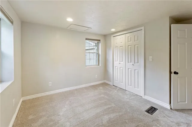 an empty room with windows and closet