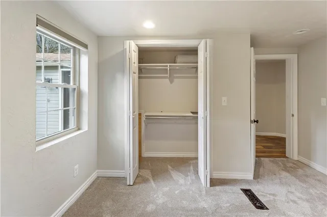 an empty room with windows and closet
