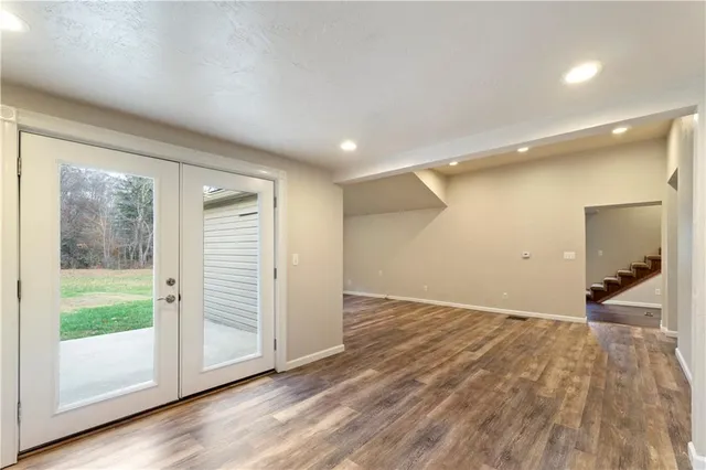 a view of a big room with wooden floor and windows