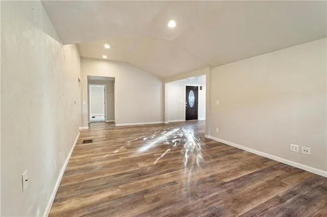 a view of a room with wooden floor and window