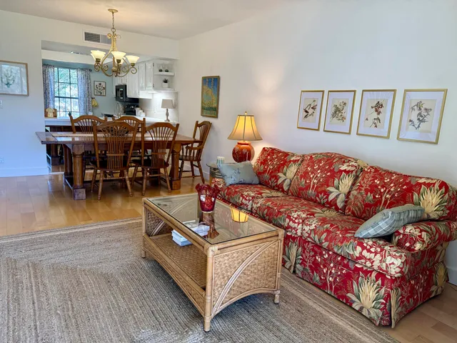 a living room with furniture kitchen view and a chandelier