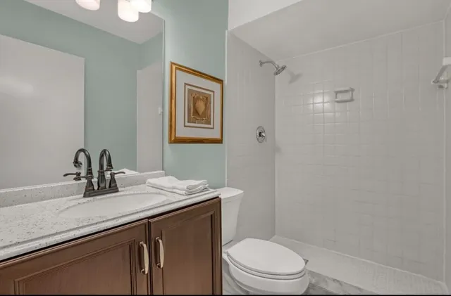 a bathroom with a granite countertop sink toilet and shower