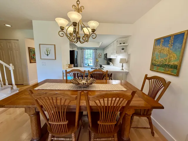 a view of a dining room with furniture a chandelier and wooden floor