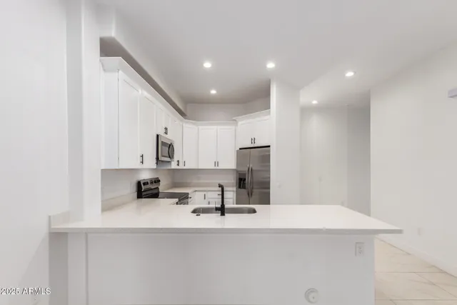 a kitchen with kitchen island a sink stainless steel appliances and cabinets