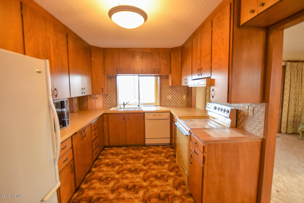 583 Ragan Road Wapato, WA 98951 - Photo 7 of 31 a kitchen with a sink stove and refrigerator