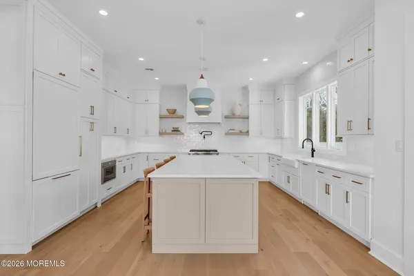 a kitchen that has a lot of cabinets in it and wooden floors