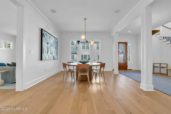 a dining room with furniture a chandelier and wooden floor