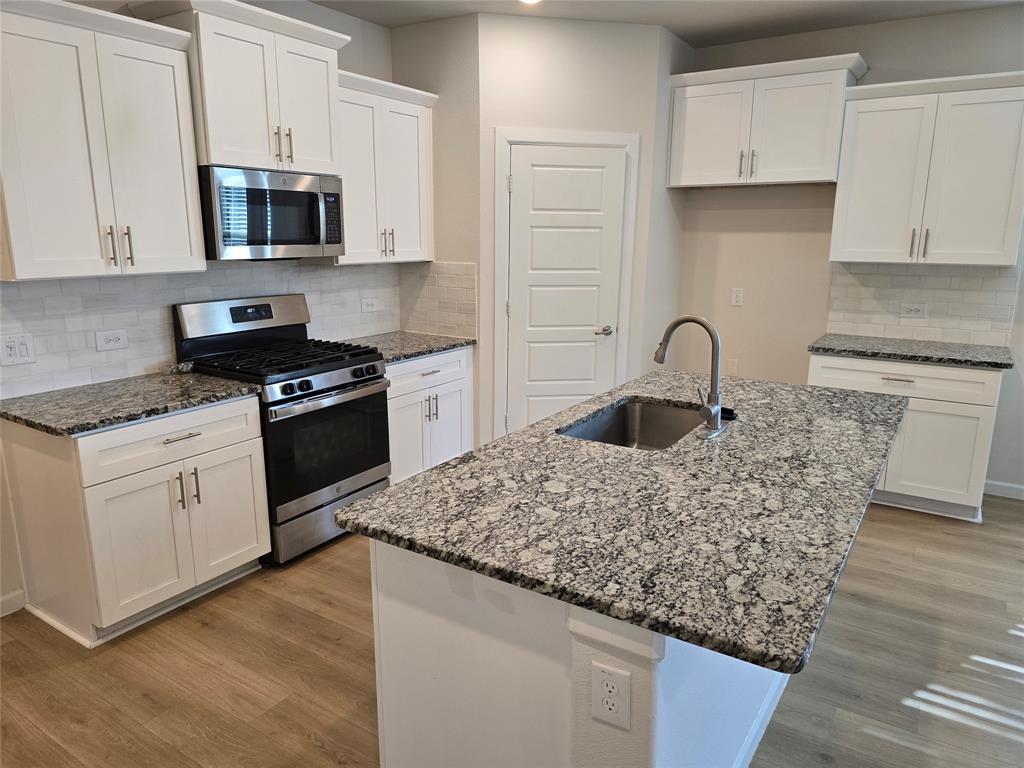 508 Williams Way Van Alstyne, TX 75495 - Photo 6 of 26 a kitchen with sink a stove and cabinets