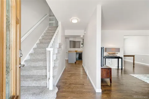 a view of a hallway with wooden floor and staircase