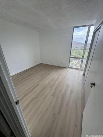 a view of an empty room and wooden floor