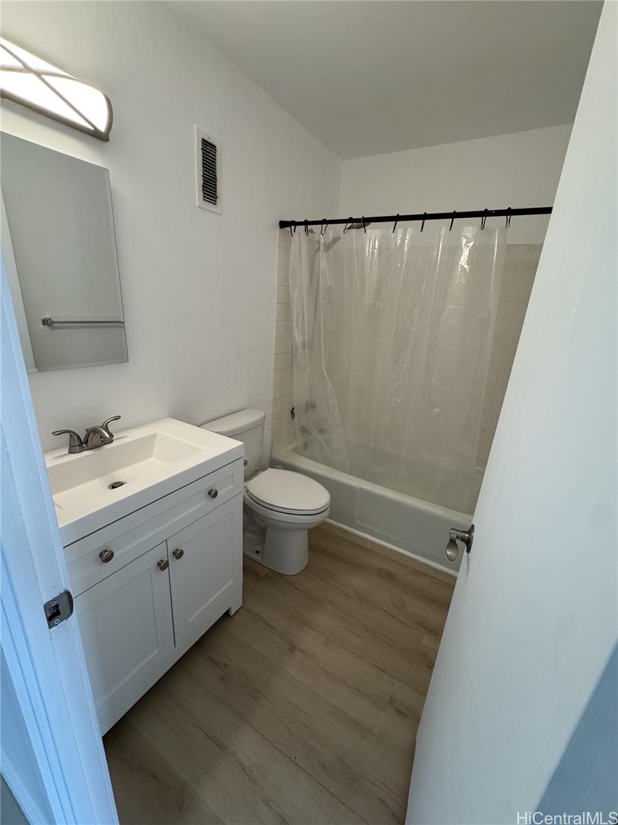 5210 Likini Street, Unit 1106 Honolulu, HI 96818 - Photo 5 of 7 a bathroom with a double vanity sink toilet and mirror