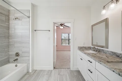 a bathroom with a granite countertop bathtub shower sink and mirror
