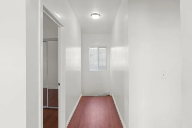 a view of a hallway with wooden floor