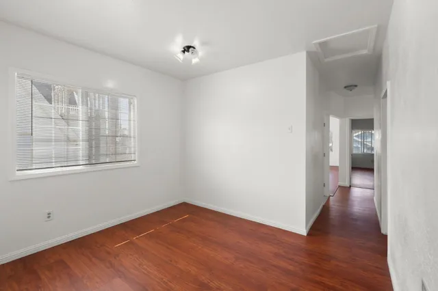 a view of a room with wooden floor and a window