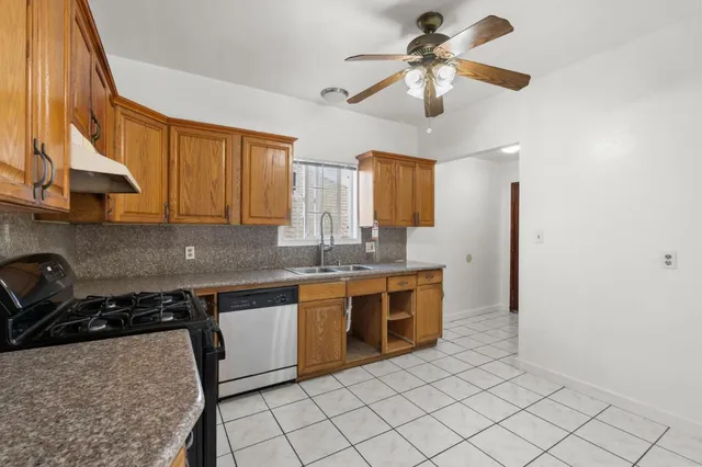 a kitchen with stainless steel appliances granite countertop a sink a stove and a refrigerator