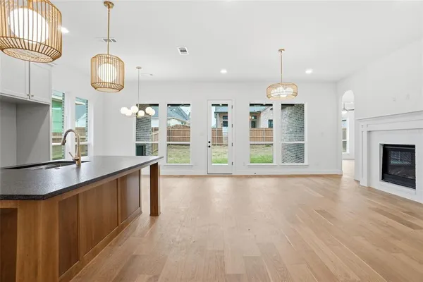 a large kitchen with granite countertop a stove and a wooden floor