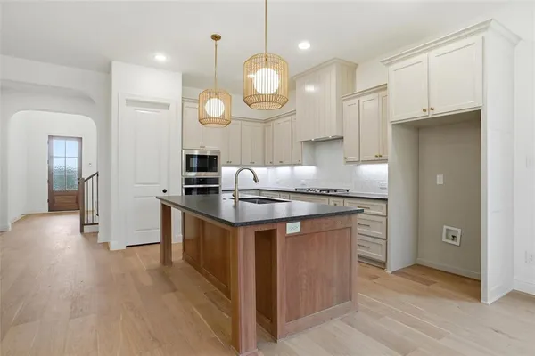 a kitchen with granite countertop a sink cabinets and stainless steel appliances