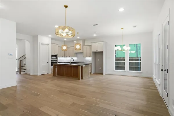 a view of a kitchen with kitchen island a counter top space stainless steel appliances and a chandelier