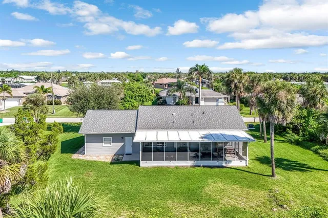 a view of a big house with a big yard and large trees