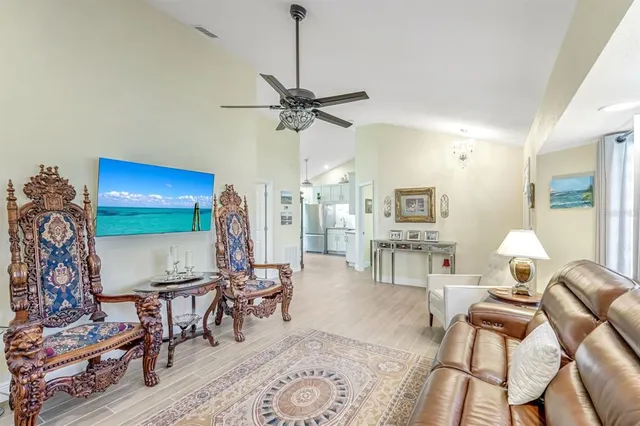 a living room with furniture a chandelier and a flat screen tv