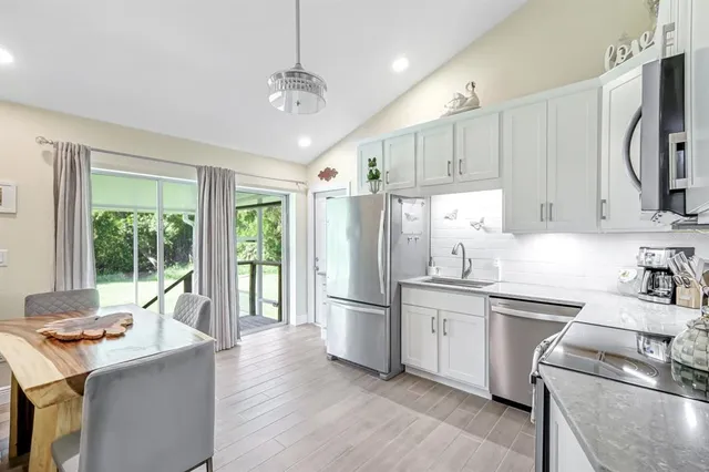 a kitchen with stainless steel appliances granite countertop a sink stove and refrigerator