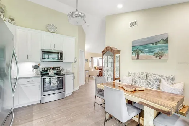 a kitchen with stainless steel appliances a dining table and chairs