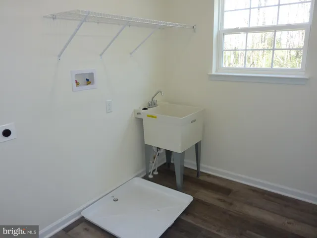 a room with a sink a desk and chair