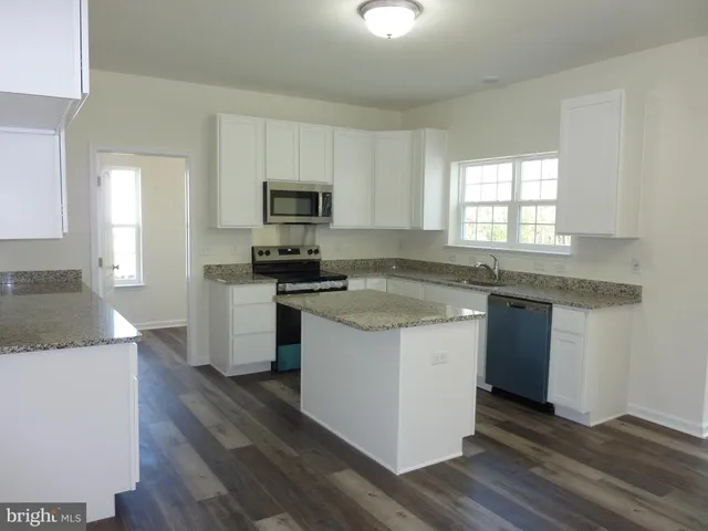 a kitchen with granite countertop a sink and steel appliances