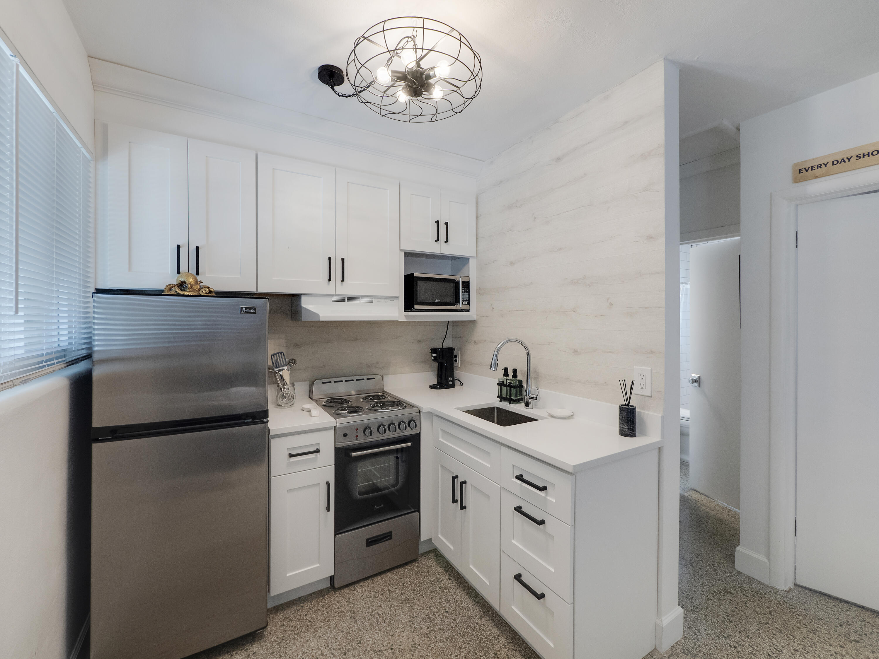 a kitchen with white cabinets and stainless steel appliances