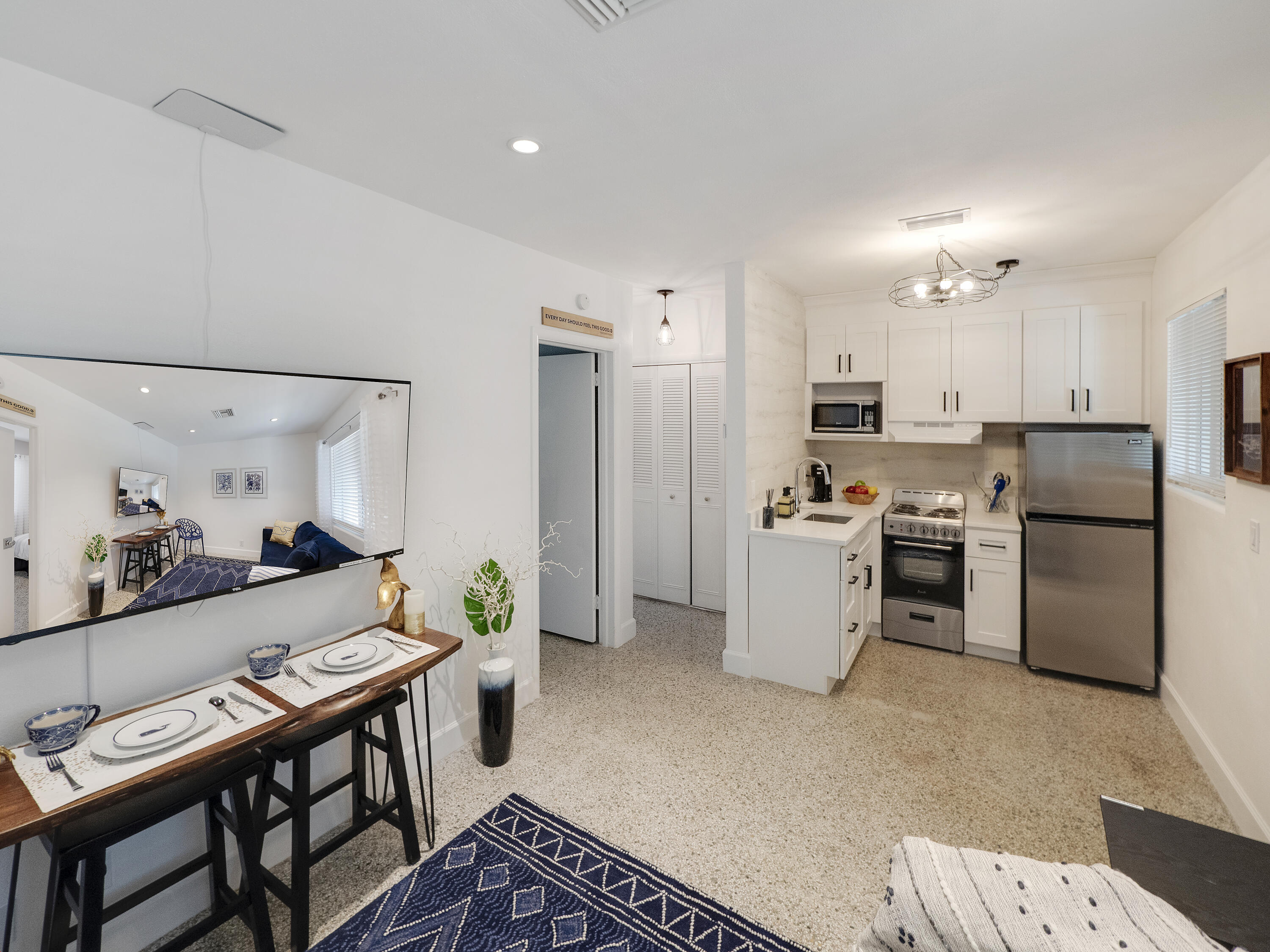 1258 Beach Road, Unit 8 Singer Island, FL 33404 - Photo 8 of 11 a kitchen with a refrigerator a stove top oven a sink dishwasher and dining table with wooden floor