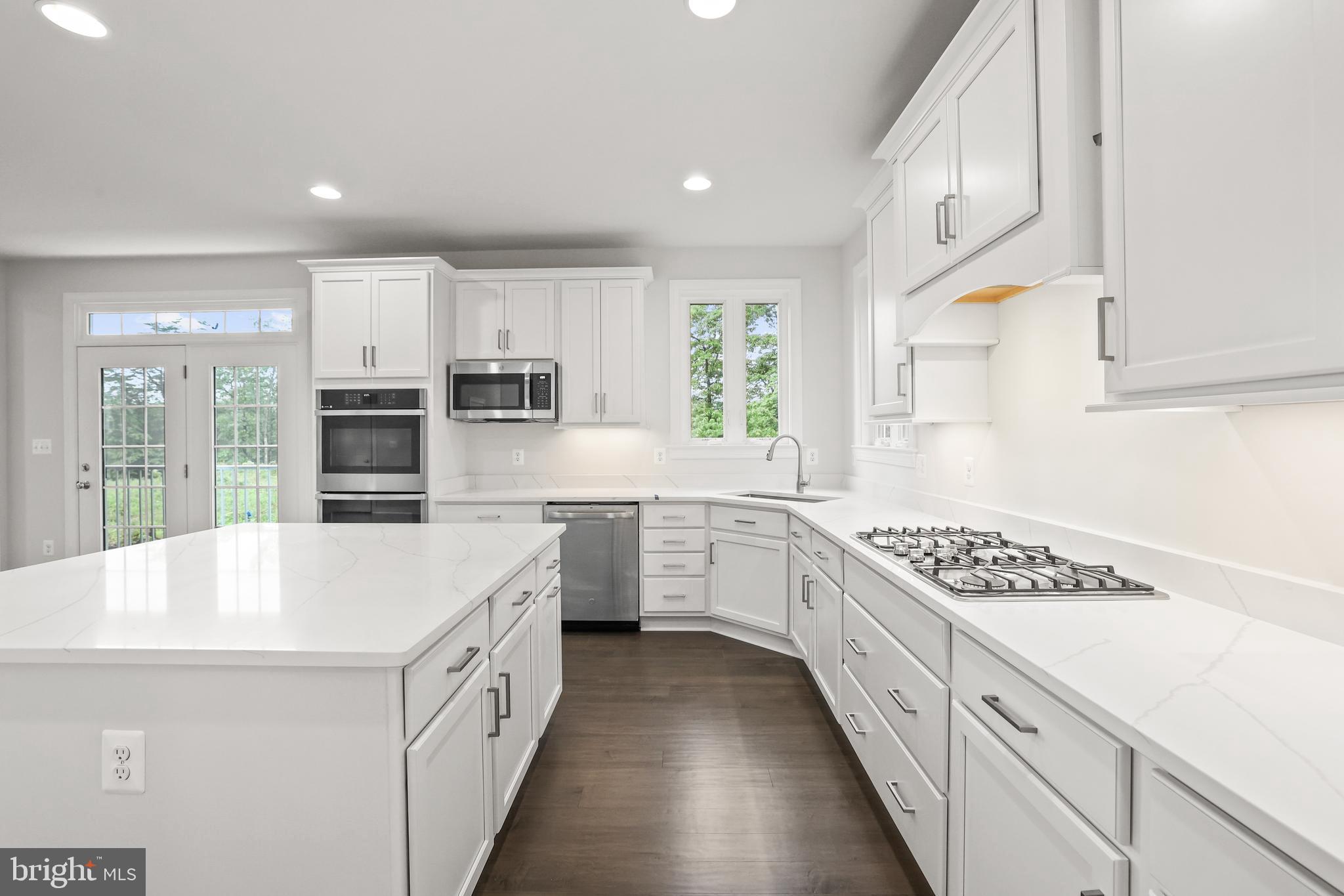 14496 Aurora Drive Woodbridge, VA 22193 - Photo 30 of 70 a large white kitchen with stainless steel appliances granite countertop a lot of counter space and wooden floors
