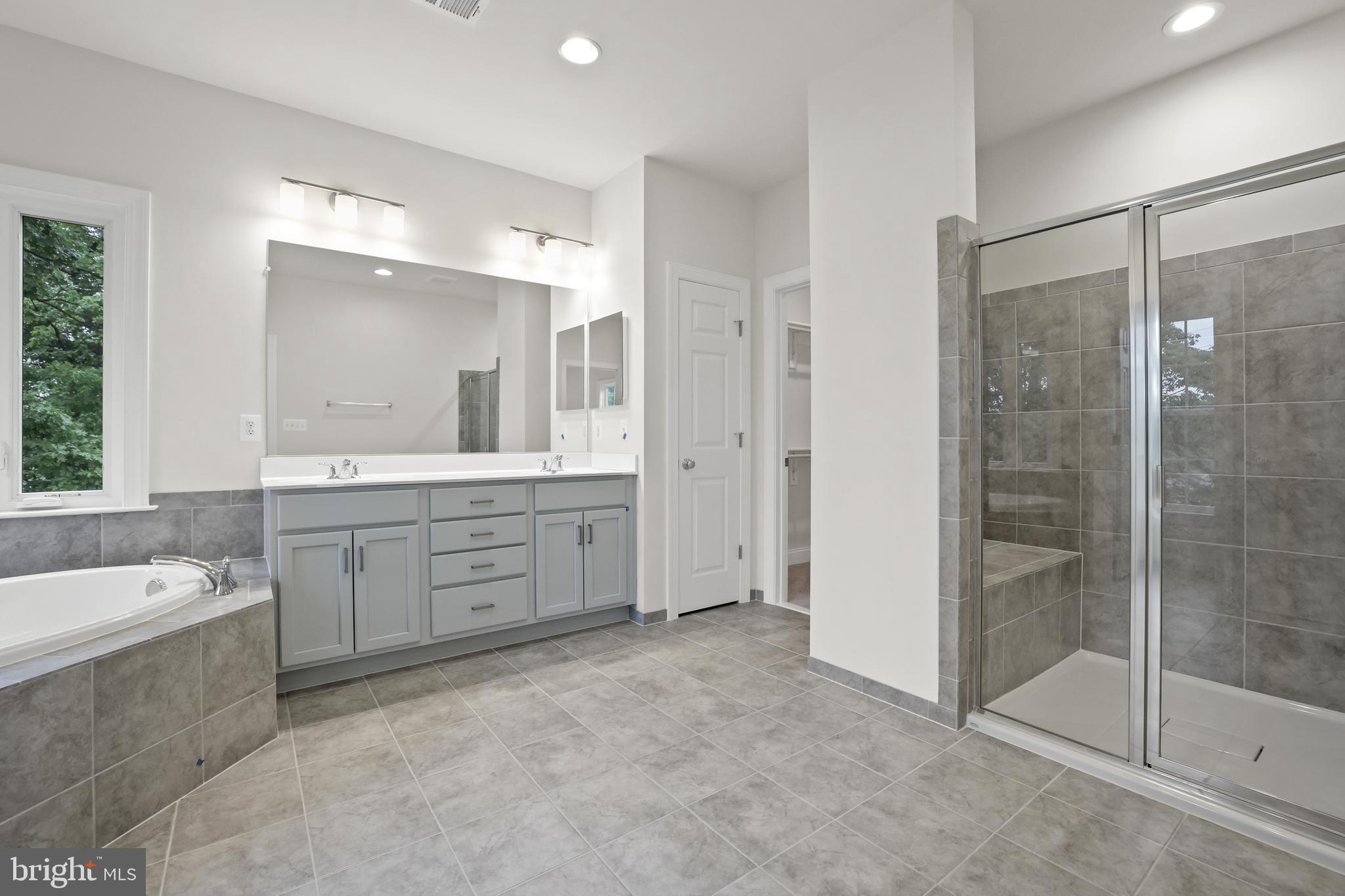 14496 Aurora Drive Woodbridge, VA 22193 - Photo 40 of 70 a bathroom with a tub a sink shower and mirror