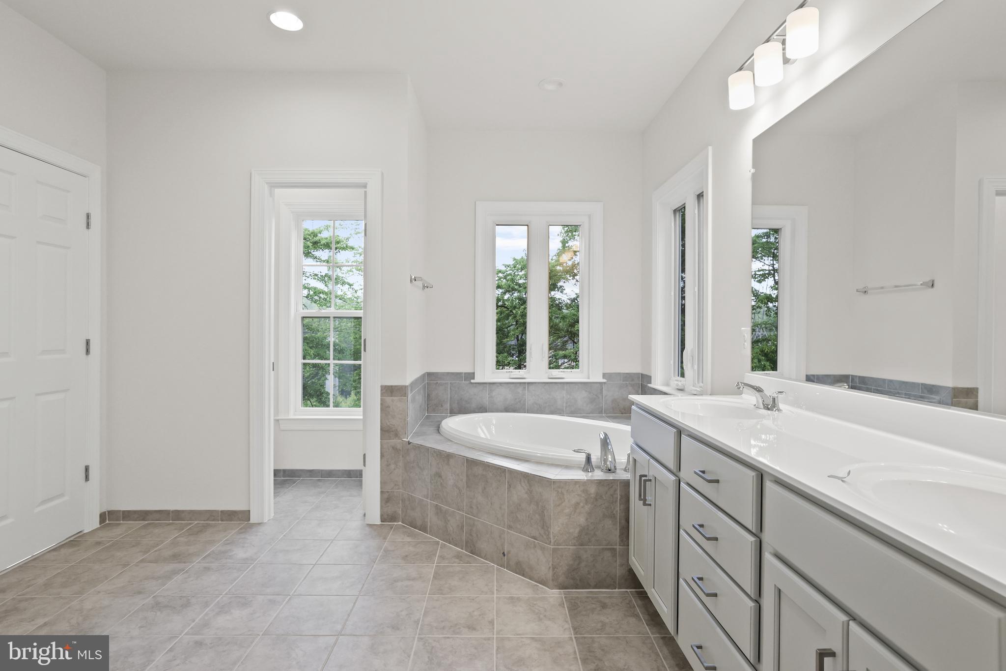 14496 Aurora Drive Woodbridge, VA 22193 - Photo 42 of 70 a bathroom with a granite countertop tub a sink and a window