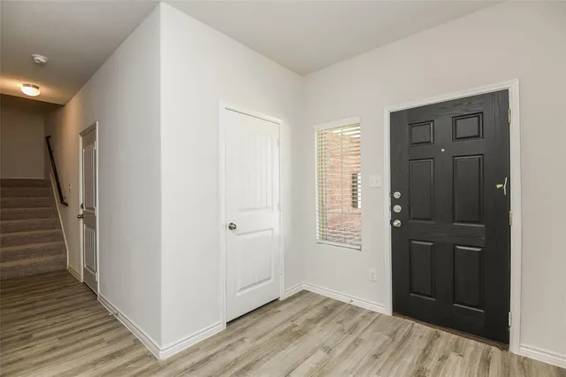 a view of kitchen with stainless steel appliances wooden floor and living room view