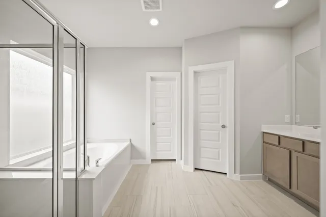a bathroom with a tub sink and mirror