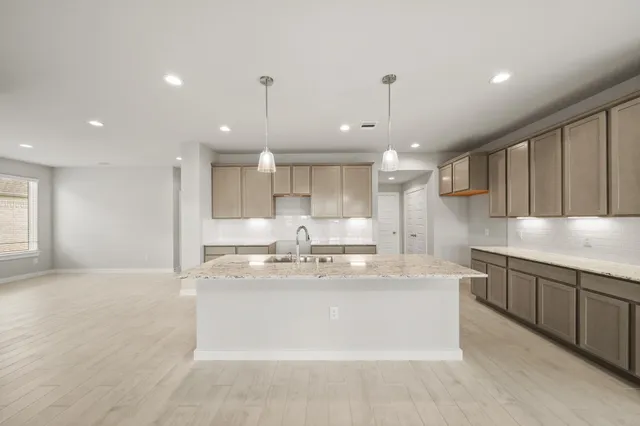 a large kitchen with kitchen island a sink stainless steel appliances and cabinets