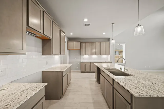 a kitchen with stainless steel appliances granite countertop a sink counter space cabinets and wooden floor
