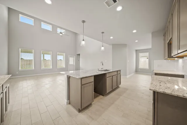 a large kitchen with granite countertop a large counter top and stainless steel appliances