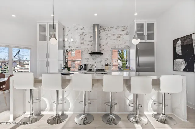 a kitchen with stainless steel appliances kitchen island granite countertop a table and chairs in it