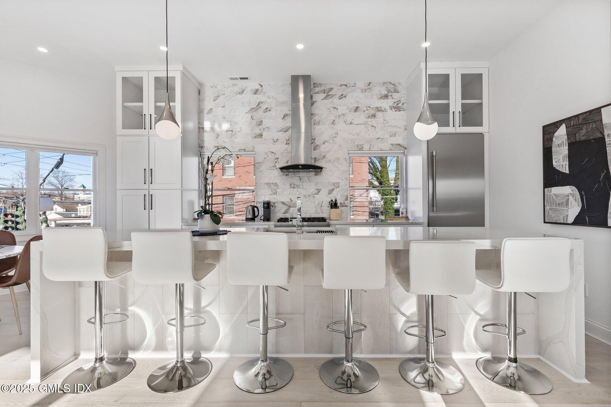 a kitchen with stainless steel appliances kitchen island granite countertop a table and chairs in it