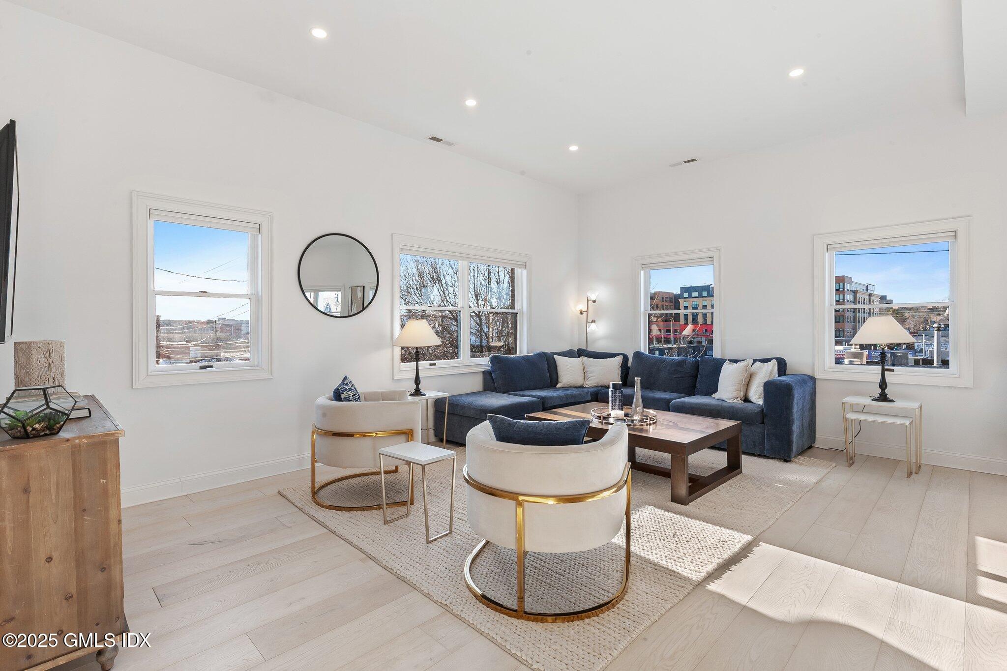 111 Mill Street, Unit PH Greenwich, CT 06830 - Photo 2 of 20 a living room with furniture a clock on wall and a window