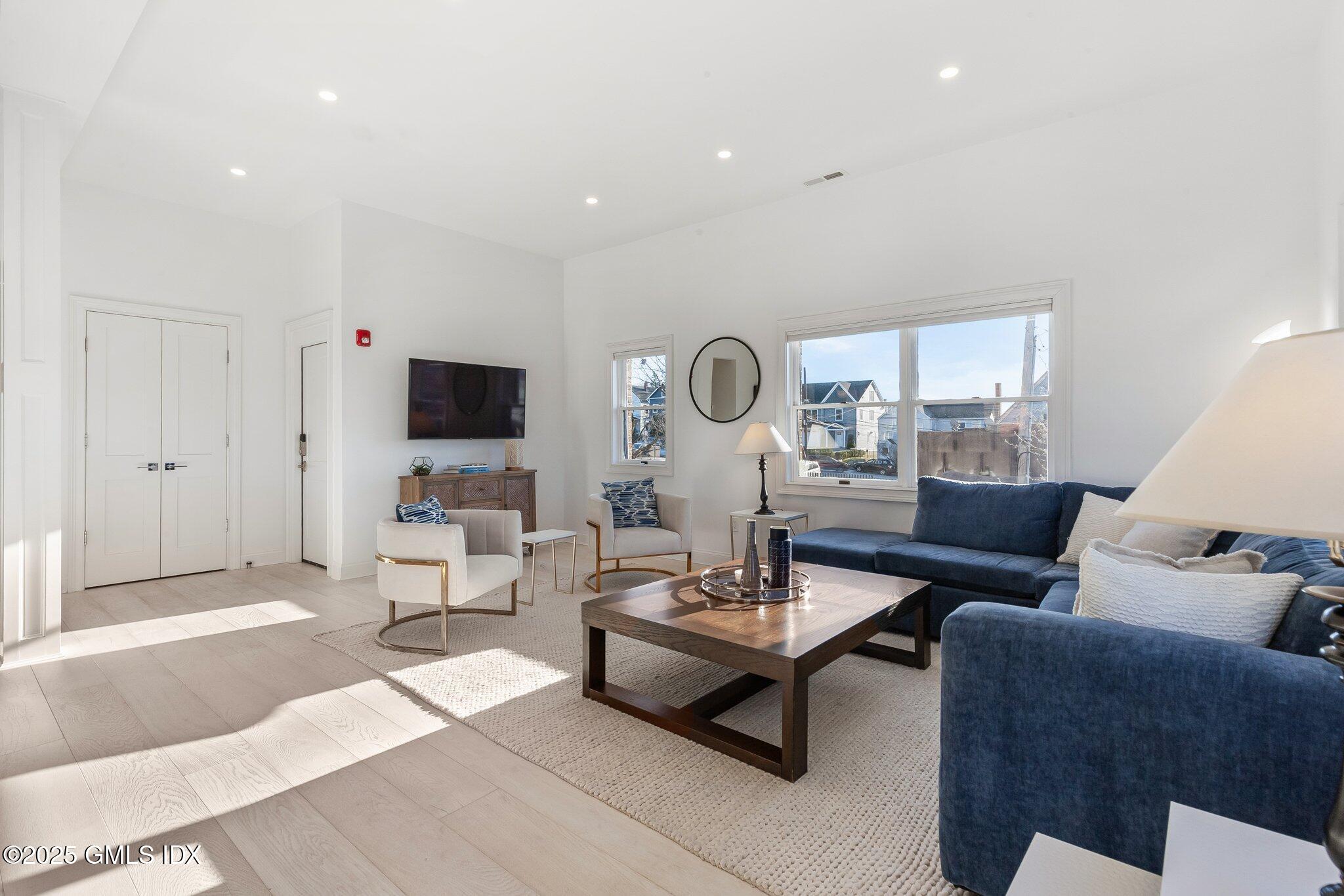 111 Mill Street, Unit PH Greenwich, CT 06830 - Photo 3 of 20 a living room with furniture and a flat screen tv