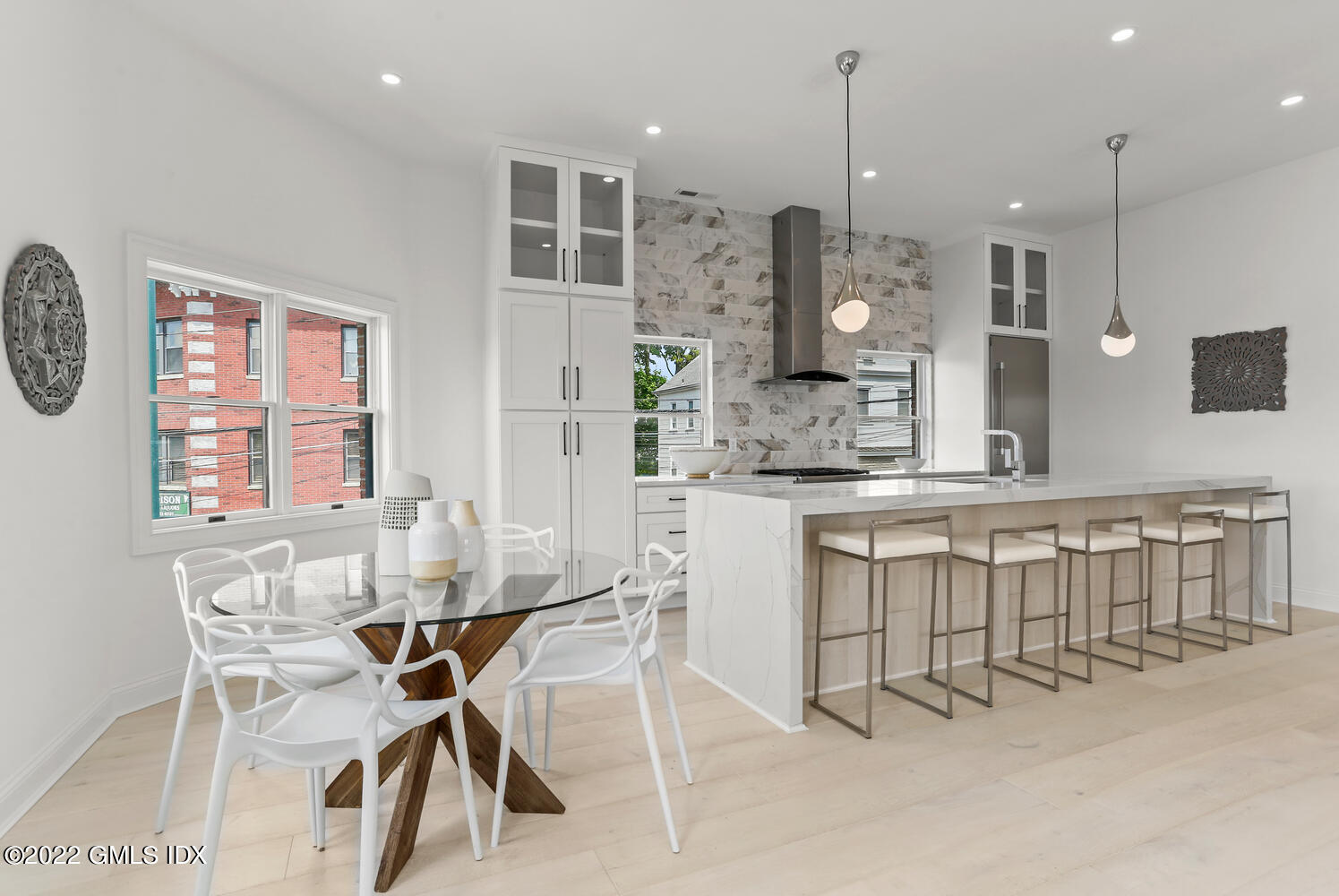 111 Mill Street, Unit PH Greenwich, CT 06830 - Photo 5 of 20 a kitchen with kitchen island a dining table chairs sink and cabinets