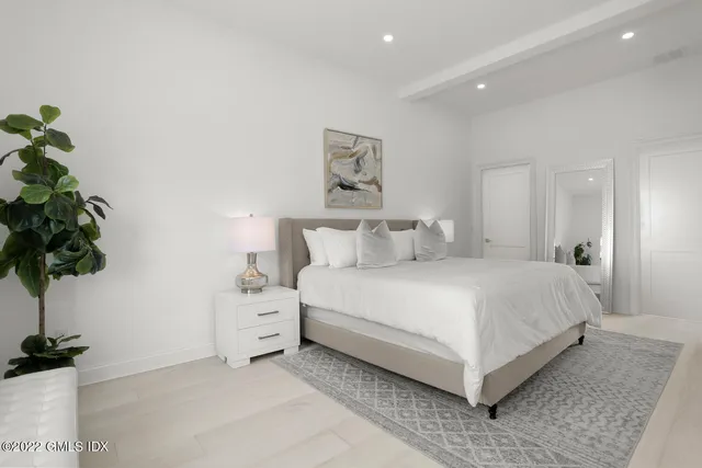 a bedroom with a bed and a potted plant