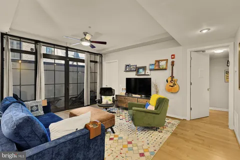 a living room with furniture a flat screen tv and a large window
