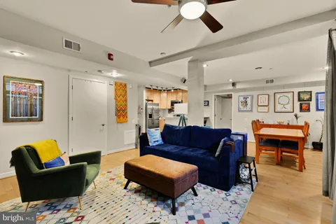 a living room with furniture a ceiling fan and a rug