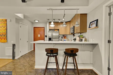 a kitchen with stainless steel appliances a table chairs refrigerator and sink