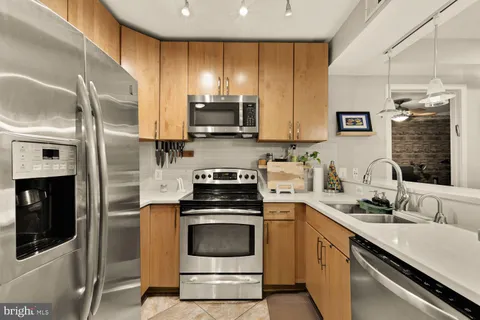 a kitchen with stainless steel appliances a stove sink and microwave