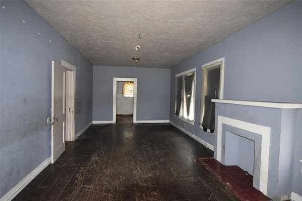 a view of an empty room with glass door and windows