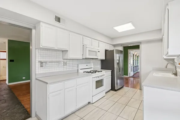 a kitchen with a sink a stove and cabinets